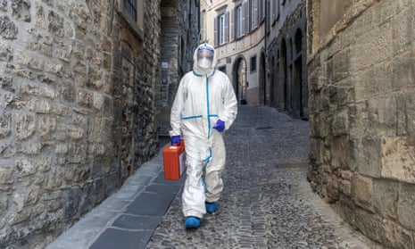 A member of the Italian Red Cross walks through an alley in Bergamo, Italy. 