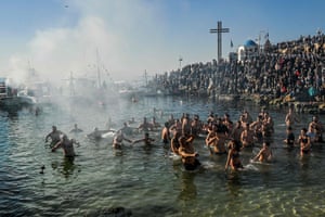Piraeus, Greece. Greek Orthodox worshippers rush to retrieve a wooden cross thrown into the sea, during the traditional blessing of water for the Orthodox Epiphany Day