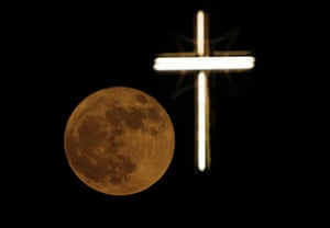 The moon rises over the cross of St. Joseph Church in Baghdad, Iraq