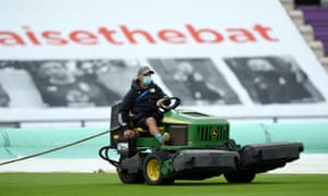 A groundsman drags a rope around the field.