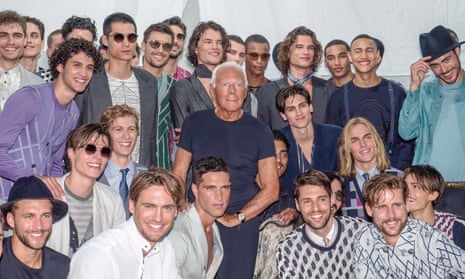 Giorgio Armani surrounded by male models