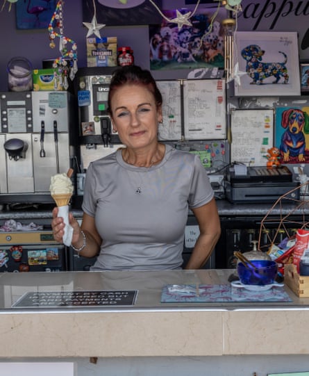 Standing in her kiosk, she holds a 99 cone for the camera