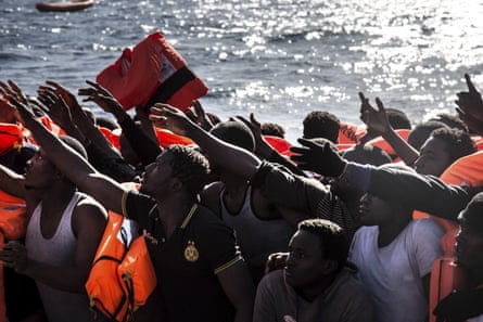 People thought to be from Nigeria, the Gambia and Senegal wait rescue from a boat in the Mediterranean, north of Libya