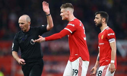 Scott McTominay (center) and Bruno Fernandes approach Referee Mike Dean