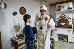 Zaporizhzhia, Ukraine. A man dressed as Saint Nicholas talks to a boy at a historical site in the city