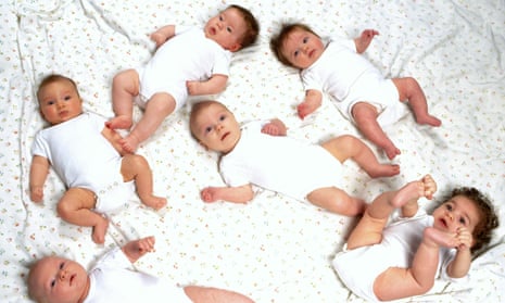 Multiple babies in a bed.