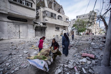 Palestinian children amid debris with items on a trolley