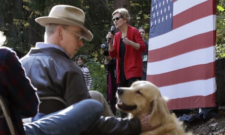 Bruce Mann pats a dog while his wife, Elizabeth Warren, speaks at a campaign event in Hanover, New Hampshire.