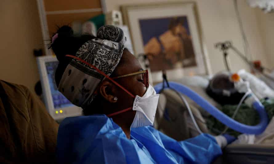 Sandie Bushnur, a hospital worker, sits bedside a Covid patient at St Mary Medical Center in Apple Valley, California in February.