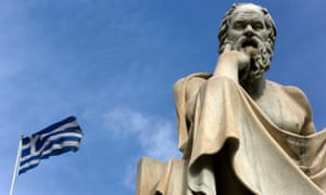 A Greek flag flutters by a statue of the philosopher Socrates in central Athens.