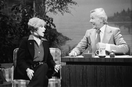 black and white photo of a woman sitting and talking next to a man at a desk