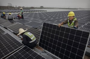 Chinese workers prepare panels that will be part of a large floating solar farm project under construction on a lake caused by a collapsed and flooded coal mine in Huainan, Anhui province, China.