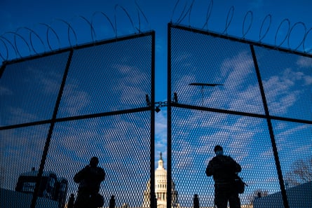National Guard troops stand behind security fencing with the dome of the Capitol building behind them, on Saturday.