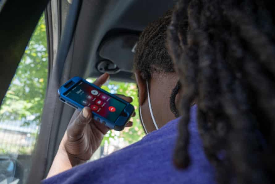 Anthony Scroggins holds his ear to his phone as he makes his way across Baltimore to meet with a Roca client suffering from a gunshot wound.