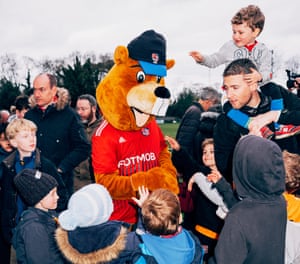 Joel Golby como mascota Bertie the Beaver saluda a los jóvenes fanáticos en un partido de fútbol