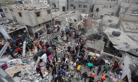 An aerial view of people searching through the rubble of destroyed buildings.