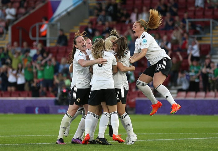 Julie Nelson (oculta) de Irlanda del Norte es acosada por sus compañeros de equipo después de anotar un gol, que es su primer gol en un torneo importante.