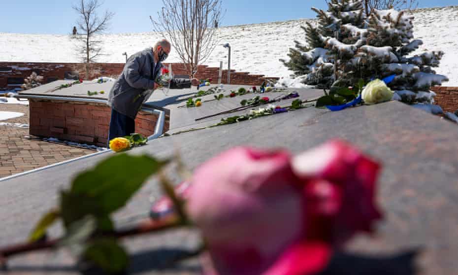 A man places flowers at Columbine  High school.