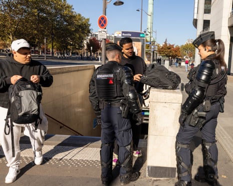 Police officers check a passersby carrying a bag at Place de la Bastille in Paris.