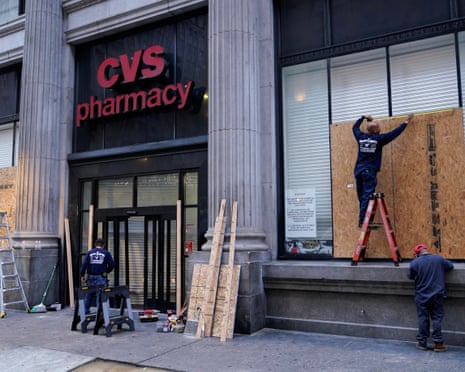 Workers board up a CVS pharmacy after it was looted in downtown Los Angeles.