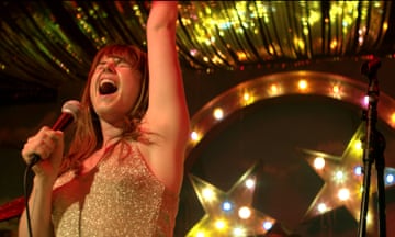 Jessie Buckley singing on stage in a scene from the film Wild Rose