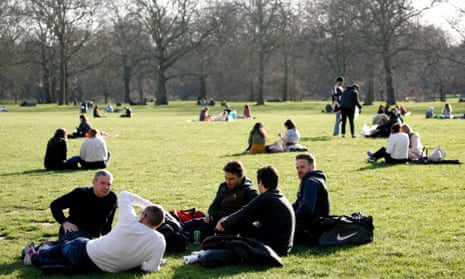 People sit in Green Park in London, early March 2021
