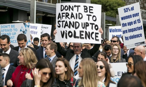 Protestors holding banners at a protest against domestic violence in Melbourne.