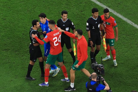 Morocco players argue with referee Abdulrahman Al Jassim and match officials after the 1-2 loss.