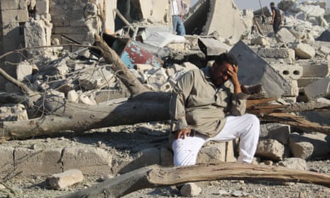 A Syrian man cries as he sits on the rubble of a building following a reported barrel-bomb attack by Syrian government forces