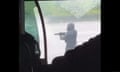A gunman seen through the window of a vehicle