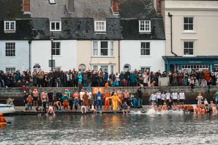 People preparing to enter the sea at a harbour Christmas dip