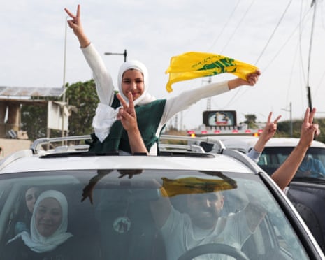 People make victory signs from a vehicle in Qasmiyeh, southern Lebanon, after the truce came into effect