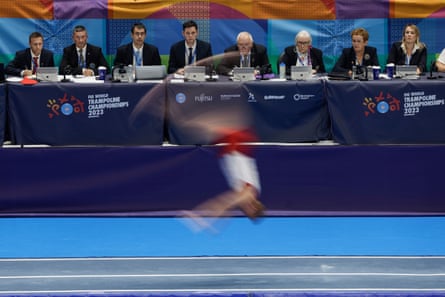 The judges watch the run of Mads Hansen of Denmark in the men’s team tumbling final