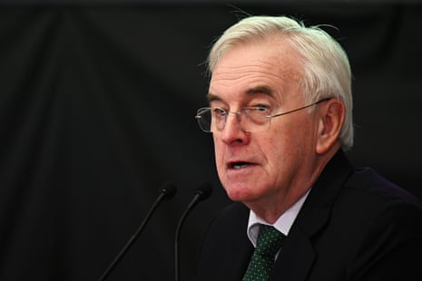 John McDonnell speaking at a rally against a dark backdrop