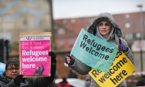 Two women hold banners saying 'Refugees welcome here'