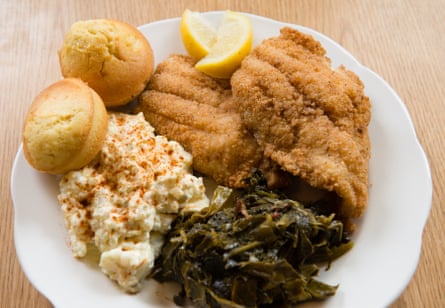 A plate of cajun-fried catfish is served with Miss Betty’s potato salad and fresh collard greens at Florida Avenue Grill in Washington DC.