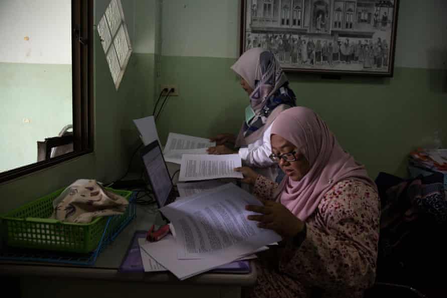 Anchana Heemmina and another woman work on a report in an office