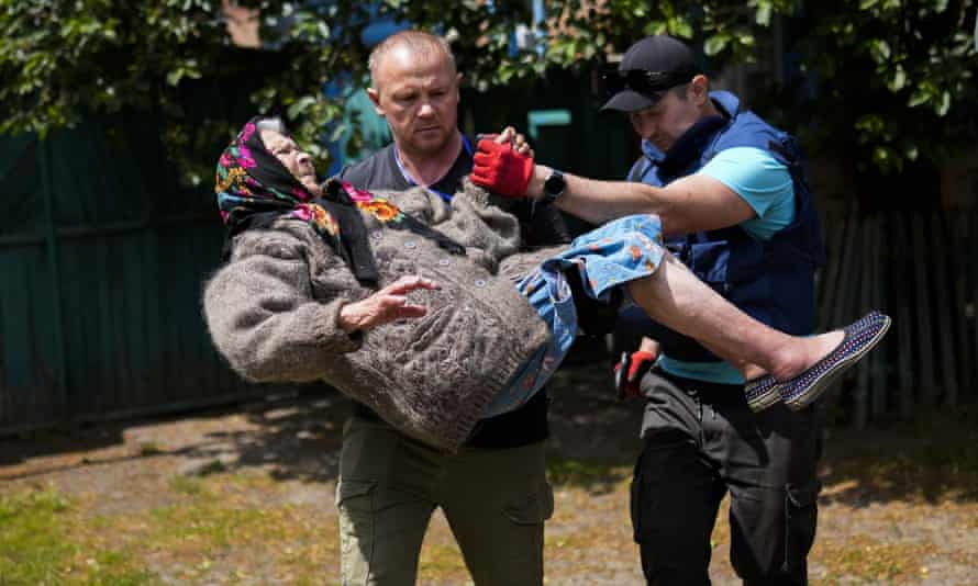 A woman is carried from her home in an evacuation by volunteers of Vostok SOS in Bakhmut, eastern Ukraine on 27 May.