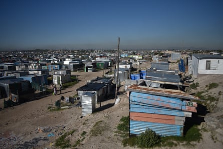 A shantytown of rows of corrugated-iron shacks with the odd small toilet shelter 
