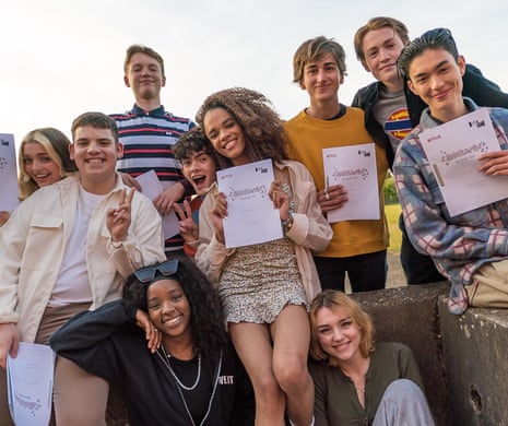 The cast of Heartstopper, smiling, hold up their scripts for episode one