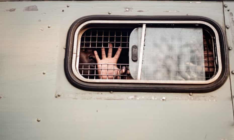 A supporter of the opposition Movement for Democratic Change is taken away in a prison van in Harare
