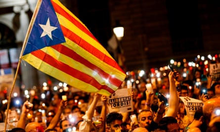 Protesters carry a Catalan pro-independence flag in Barcelona after the arrest of two separatist leaders.