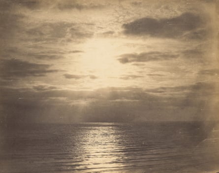 Photograph of the sea reflecting the light from the sun and the cloud-dotted sky