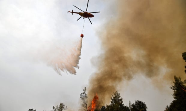 A helicopter pours water on a wildfire near the village of Kechries in Greece.