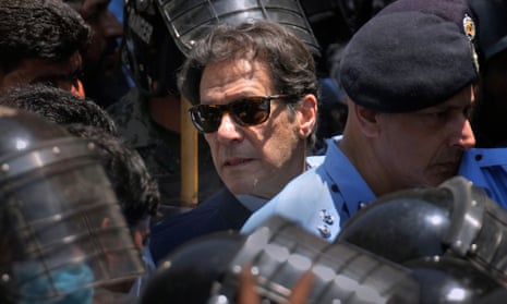 Imran Khan arrives for a court appearance, escorted by police officers