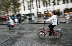 A woman rides her bicycle on the Champs-Élysées in Paris
