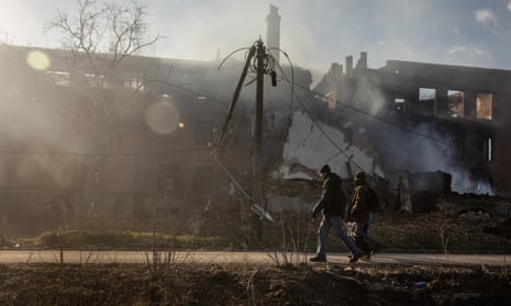 Los residentes pasan frente a un edificio en llamas en Bakhmut, Ucrania, que fue alcanzado por los bombardeos rusos el 14 de diciembre.