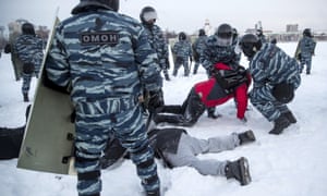 Police in riot gear and camouflage uniformed two people in the snow