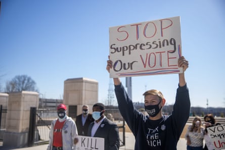 Protesters gather, holding placards against the proposed voting changes.