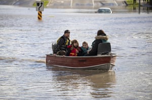 people in a boat in flooded waters